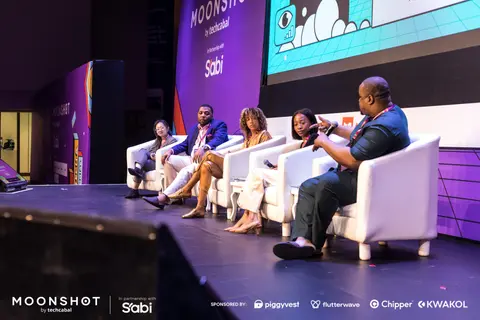 A panel discussion on the main stage beneath a large screen.
