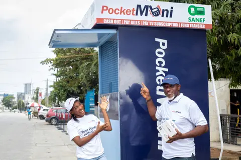 Agents in PocketMoni shirts outside a roadside kiosk.