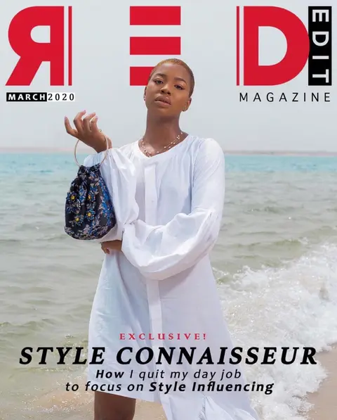 Red Edit magazine cover: a woman in a white dress holding a beaded bag at the shoreline.